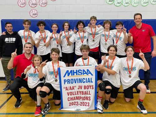 The boys junior varsity Les Roys show off their new banner. (MHSAA)